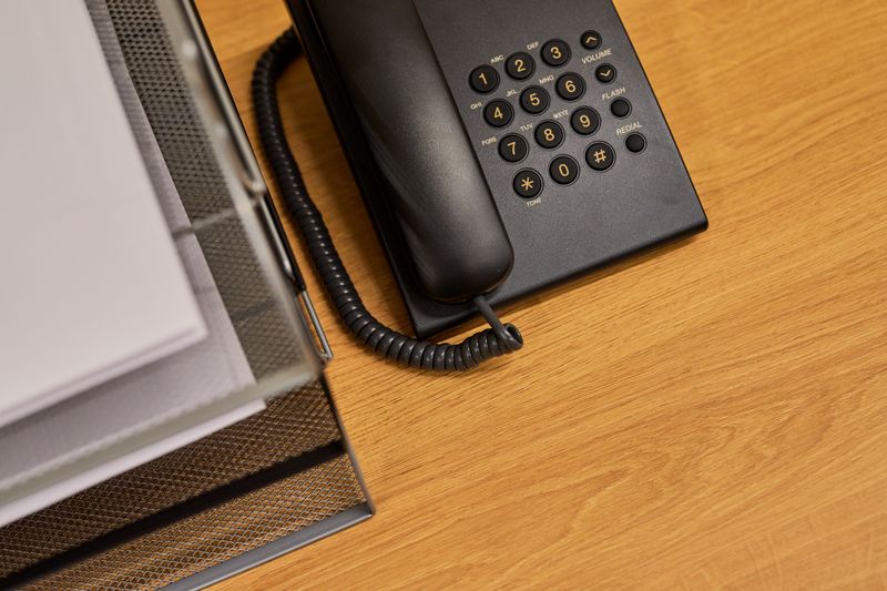 Black desk phone beside document organizer