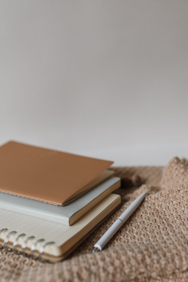 Neutral notebooks and pen on textured fabric