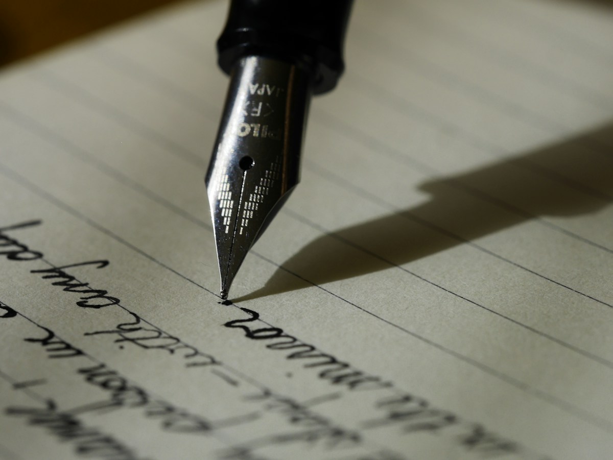 A fountain pen resting on handwritten notes